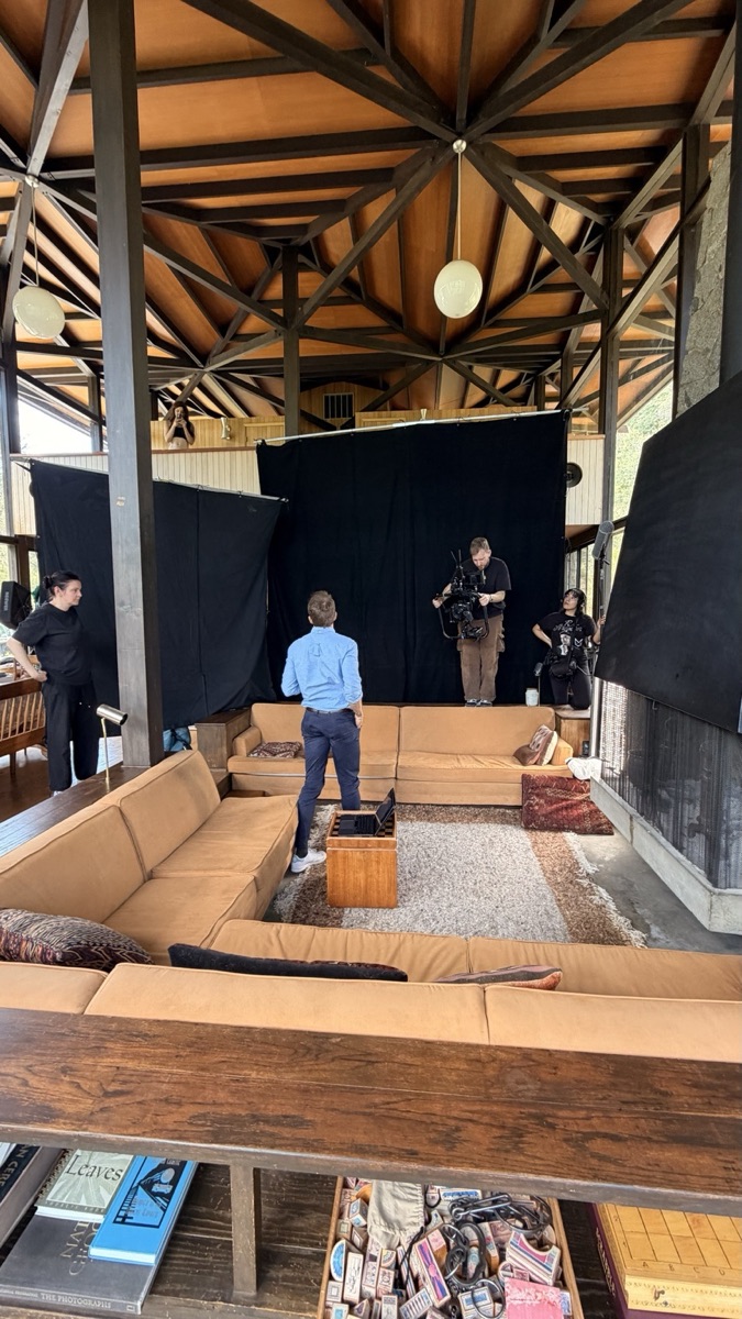 Crew working in front of a black backdrop under a wood-beamed ceiling